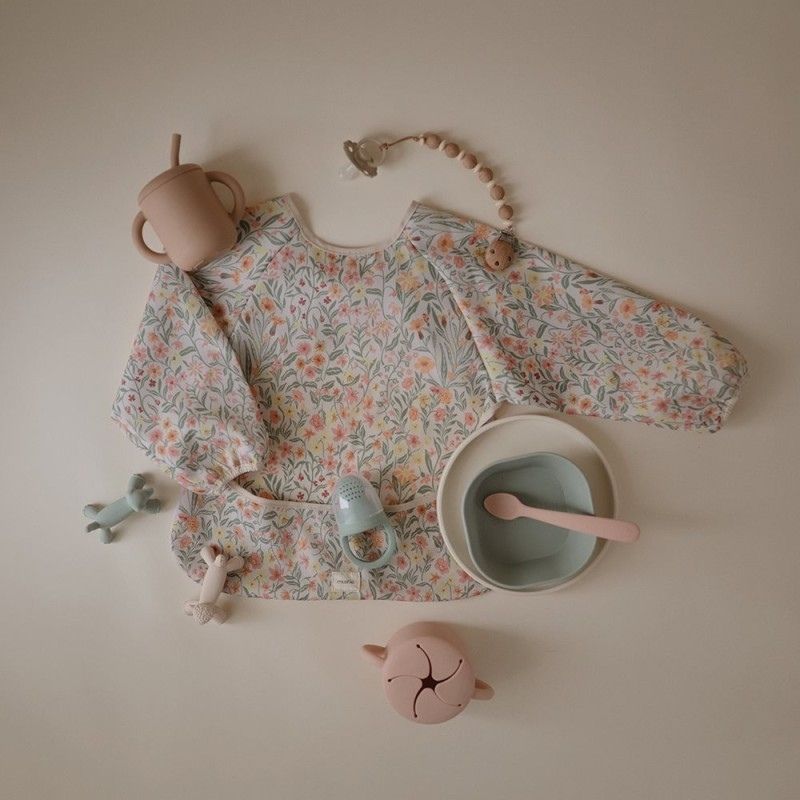 Babete impermeável com mangas pastel bloom da Mushie 2